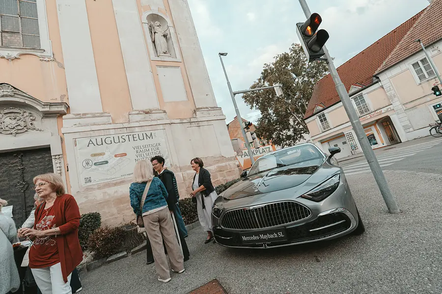 Gäste stehen vor dem Augusteum neben einem silbernen Mercedes